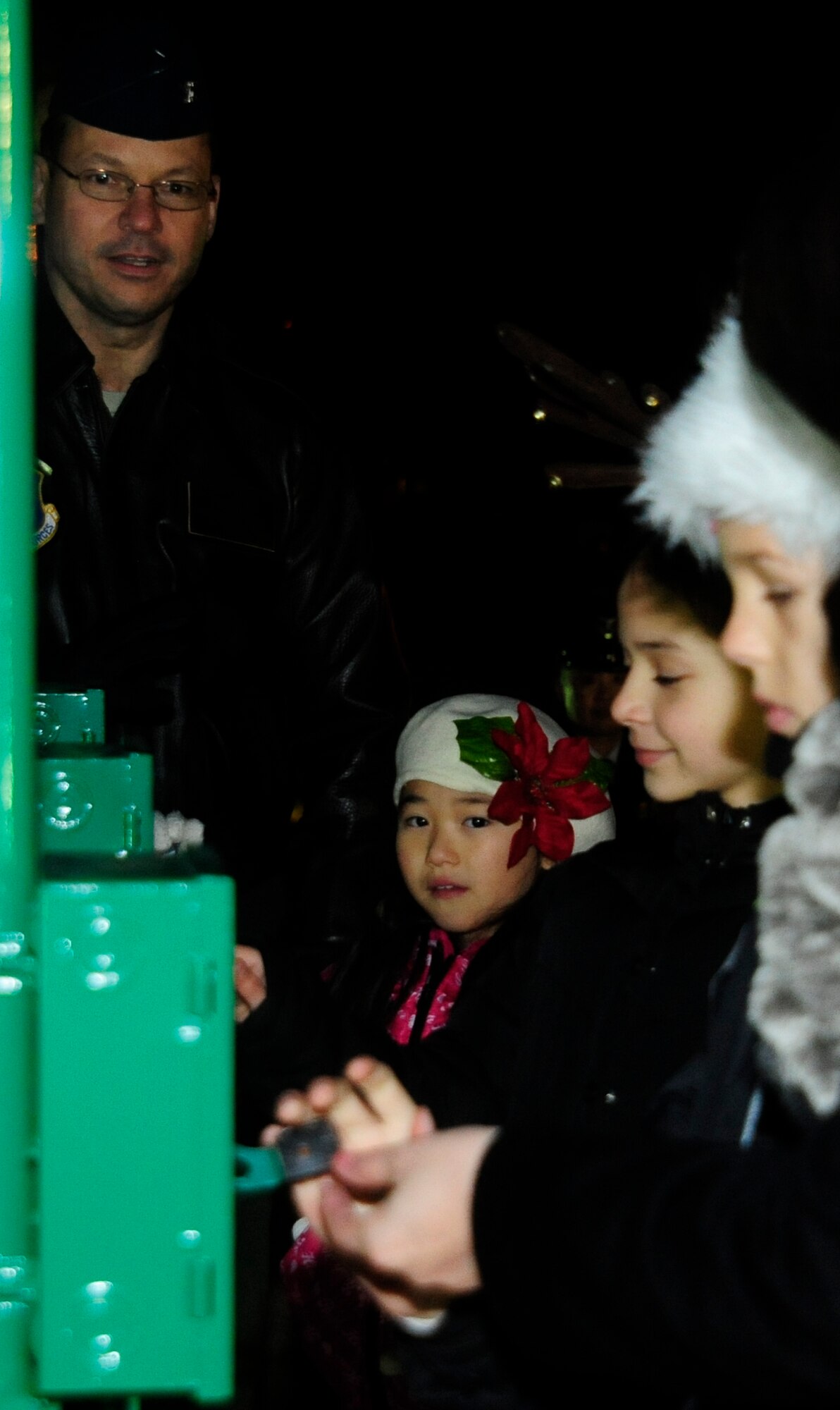 U.S. Air Force Col Stephen Williams, 35th Fighter Wing commander, looks on as children from the Misawa Boys and Girls Club, Sollars Elementary choir and Awana Club turn on the lights of the base tree during the tree lighting ceremony on Misawa Air Base, Japan, Dec. 6, 2013. This yearly tradition is a chance to bring families together for treats and entertainment to welcome the holiday season. (U.S. Air Force photo by Tech. Sgt April Quintanilla)