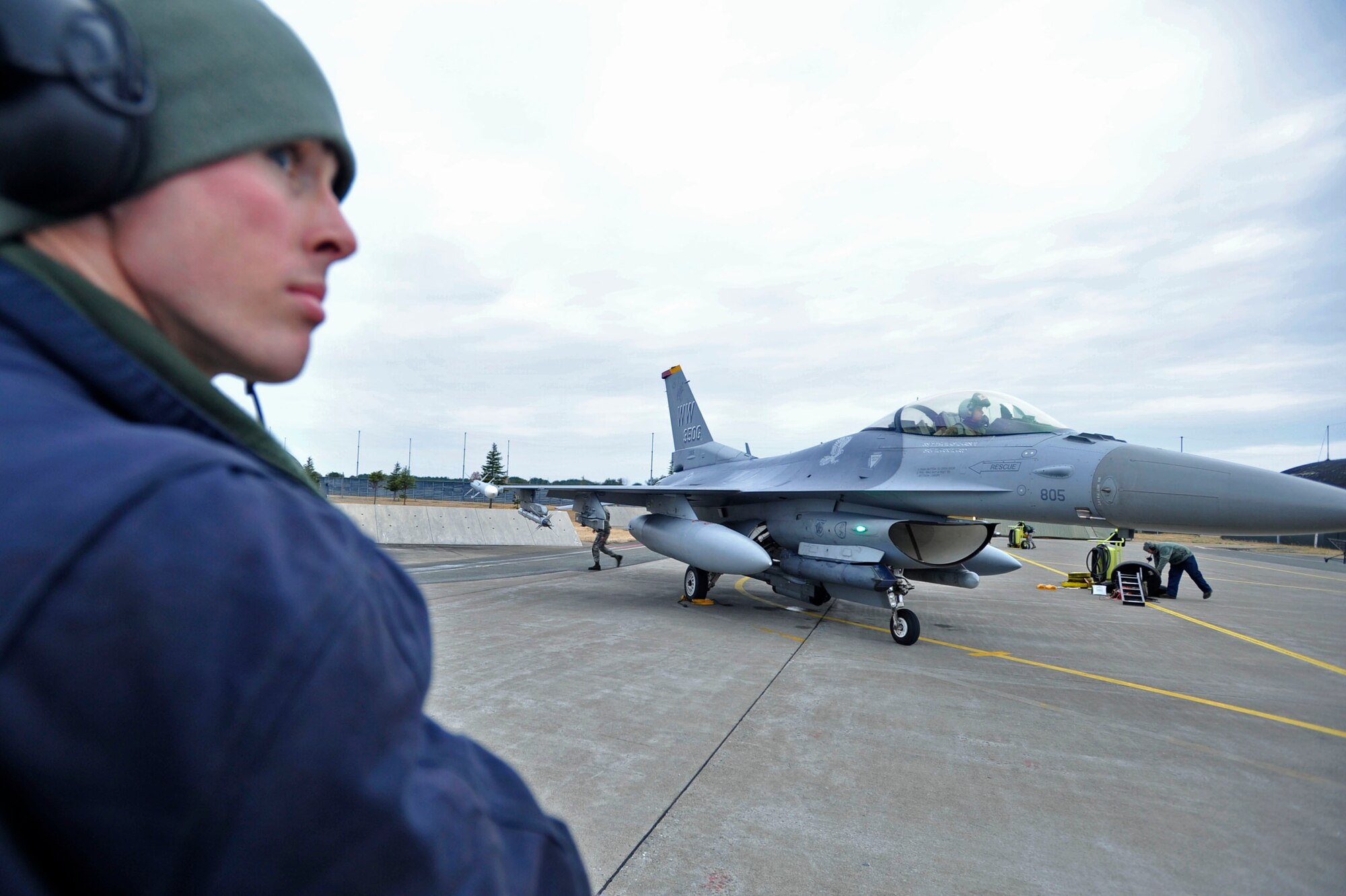 MISAWA AIR BASE, Japan – U.S. Air Force Staff Sgt. Thomas Larson, 14th Aircraft Maintenance Unit crew chief, scans the flightline before marshalling an F-16 Fighting Falcon into a parking space on Misawa Air Base, Japan, Dec. 10, 2013. Larson was recently selected to become the dedicated crew chief for the 35th Operations Group commander’s flagship aircraft. (U.S. Air Force photo by Staff Sgt. Tong Duong)