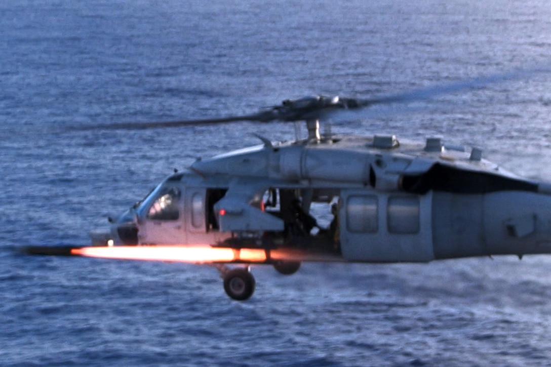 An MH-60S Seahawk helicopter fires an AGM-114 Hellfire air-to-surface missile at simulated enemy personnel during a live-fire, close-air support training at Farallon de Medinilla Target Range, Northern Mariana Islands, Dec 10, 2013.