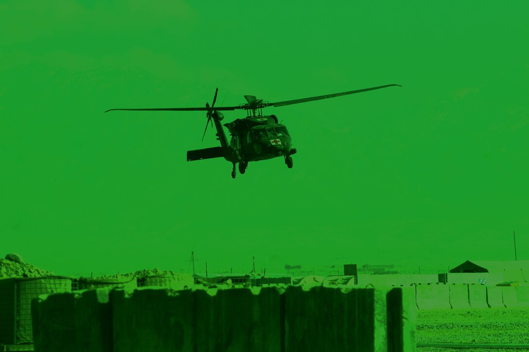 As seen through a night-vision device, a U.S. Army HH-60M Black Hawk helicopter makes its approach into the forward arming and refueling point on Forward Operating Base Shank after completing a medical evacuation mission over Afghanistan, Dec. 4, 2013. The helicopter crew is assigned to the 10th Combat Aviation Brigade.