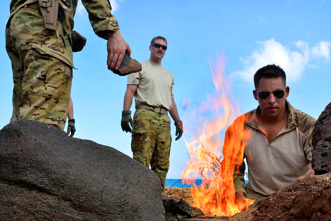 U.S. Air Force Staff Sgt. Jonathan Schmitz, right, shows other airmen how to build a fire during desert and coastline combat survival training in Djibouti, Dec. 6, 2013. Schmitz, a survival, evasion, resistance and escape specialist, is deployed in support of Combined Joint Task Force-Horn of Africa. 