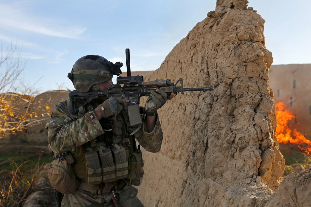A U.S. soldier, along with Afghan army commandos, conduct a clearance operation of Perozi village in Panjwai district in Kandahar province, Afghanistan, Dec. 4, 2013. The soldier is assigned to Combined Joint Special Operations Task Force-Afghanistan.
