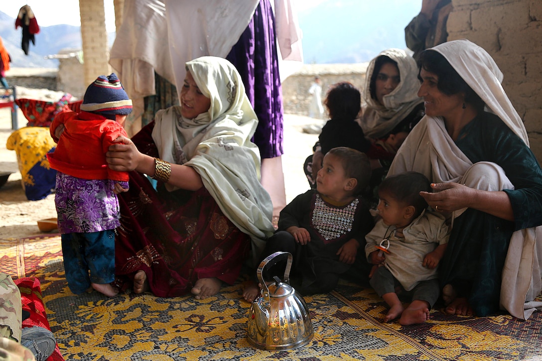 Local Afghan women and children gather around female U.S. soldiers in the Sarobi district of Kabul province, Afghanistan, Dec. 6, 2013. The female soldiers met with the local populace to address general concerns in their villages.