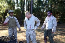 Simulated casualties with 2nd Medical Battalion, Combat Logistics Regiment 25, 2nd Marine Logistics Group prepared for chaos to ensue during a mass casualty exercise aboard Camp Lejeune, N.C., Dec 12, 2013. The casualties laid in a football field while simulated improvised explosive devices detonated and acting insurgents attacked their fellow Marines and sailors who were coming to their rescue. (U.S. Marine Corps photo by Lance Cpl. Shawn Valosin)