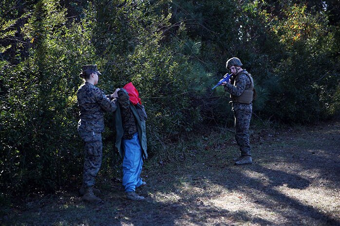 Service members with 2nd Medical Battalion, Combat Logistics Regiment 25, 2nd Marine Logistics Group practice safely detaining an insurgent during a mass casualty exercise aboard Camp Lejeune, N.C., Dec 12, 2013. The exercise brought some of the realism from the battlefield to home and prepared new Marines and sailors for future deployments. (U.S. Marine Corps photo by Lance Cpl. Shawn Valosin)