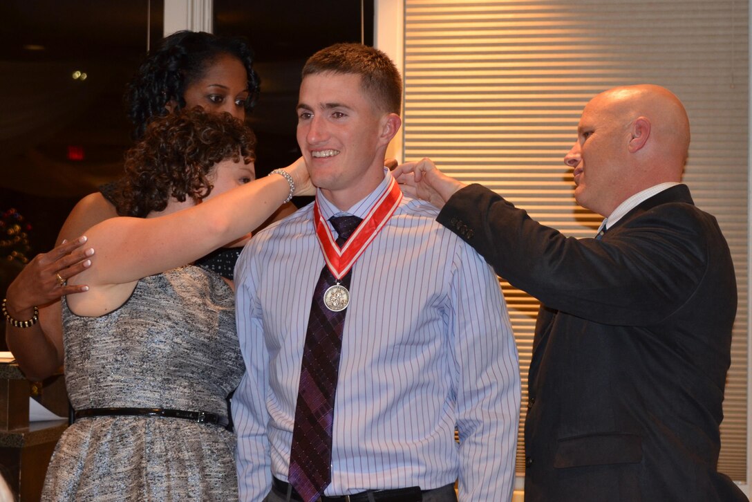 ALBUQUERQUE, N.M., -- Lt. Col. Antoinette Gant watches as Jamie Larson and Maj. Gary Bonham present Capt. Christopher Larson with the Steel de Fleury Medal, Dec. 6, 2013. 