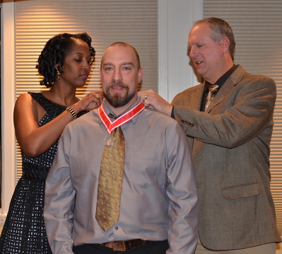 ALBUQUERQUE, N.M., -- Lt. Col. Antoinette Gant and Chief of Regulatory Division Allan Steinle present Chris Parrish, regulatory project manager and archeologist, with the Steel de Fleury Medal for his outstanding work ethic and demonstration of the Army values, Dec. 6, 2013. 