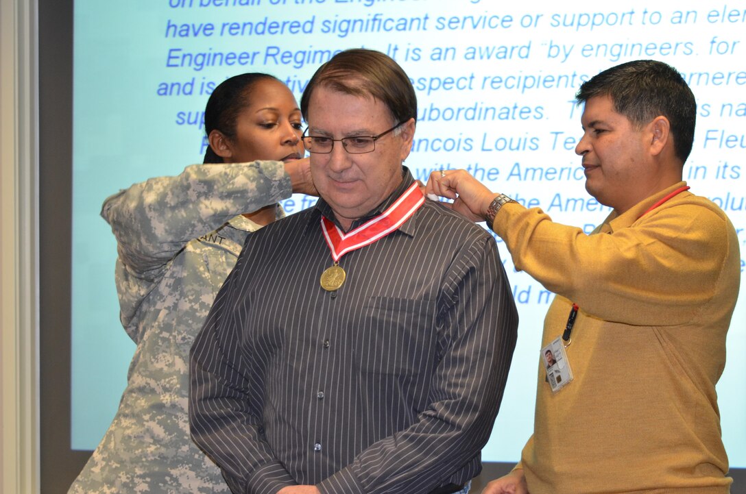ALBUQUERQUE, N.M., -- Lt. Col. Antoinette Gant and Chief of Engineering and Construction John Moreno present Glenn Roybal, chief of the Cost Engineering Section, with the Bronze de Fleury Medal "for inspirational leadership to the United States Army Corps of Engineers," Dec. 12, 2013.