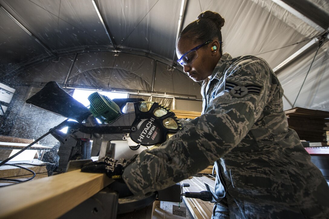 Senior Airman Marita McCoy uses a saw to cut a piece of wood Dec. 3, 2013, at Transit Center at Manas, Kyrgyzstan. McCoy used the wood to build the foundation of a scale to weigh cargo. McCoy is an inbound specialist with the 376th Expeditionary Logistics Readiness Squadron. (U.S. Air Force photo/Senior Airman George Goslin)