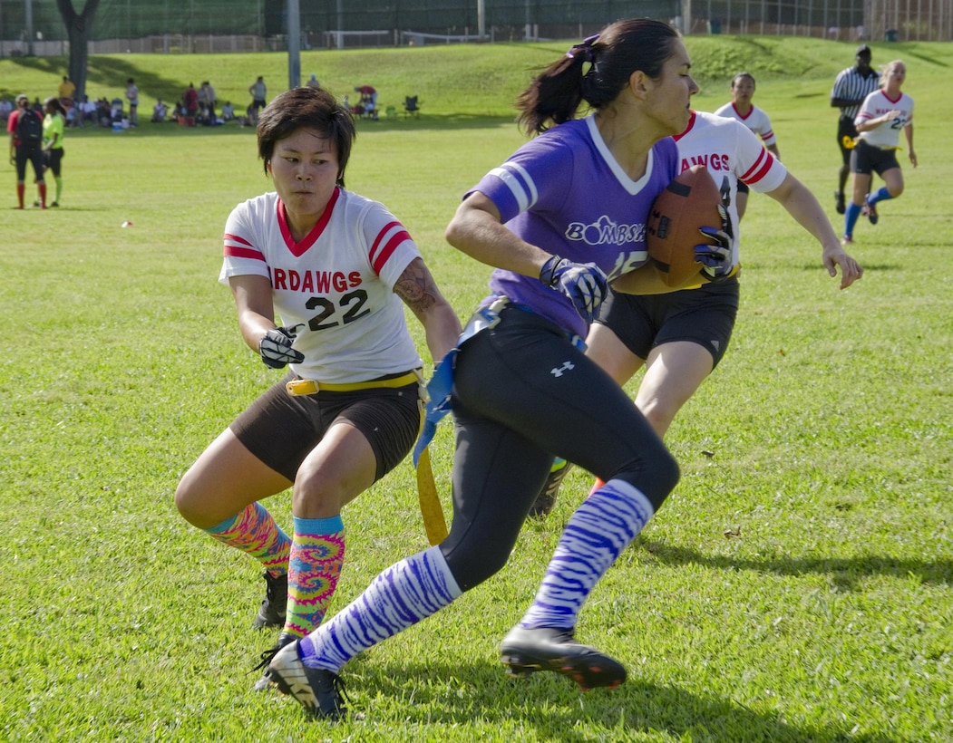 Wardawgs’ player Shannon Nagasako (left) attempts to pull the flag from a Bombshells’ player during a Hawaii Gridiron League flag football game at Kaneohe District Park, Dec. 8, 2013. The Bombshells defeated the Wardawgs, 22-18, and are heading for the championship game. (U.S. Marine Corps photo by Kristen Wong)