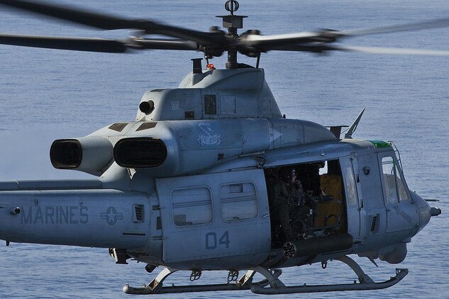 A Marine with Marine Light Attack Helicopter Squadron 367 looks out at the ocean from a UH-1Y Huey helicopter during a commemoration flyover of the USS Missouri and the USS Arizona Memorial in Pearl Harbor, Dec. 5, 2013. “Scarface” celebrated its 70th anniversary in the Marine Corps, Dec 1., and flew four AH-1W Super Cobra and UH-1Y Huey helicopters over Pearl Harbor to commemorate its history. (U.S. Marine Corps photo by Lance Cpl. Matthew Bragg)