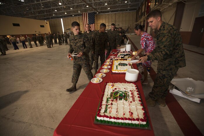 Marines with Marine Light Attack Helicopter Squadron 367 line up to receive birthday cake after a cake cutting ceremony to celebrate the unit's 70th anniversary in the Marine Corps at Hangar 101 aboard Marine Corps Air Station Kaneohe Bay, Hawaii, Dec. 2, 2013. Alumni who previously served as a part of HMLA-367 were also in attendance during the ceremony. (U.S. Marine Corps photo by Lance Cpl. Matthew Bragg)