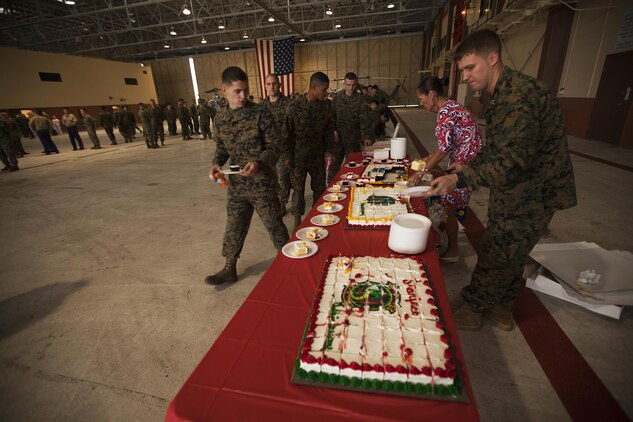 Marines with Marine Light Attack Helicopter Squadron 367 line up to receive birthday cake after a cake cutting ceremony to celebrate the unit's 70th anniversary in the Marine Corps at Hangar 101 aboard Marine Corps Air Station Kaneohe Bay, Hawaii, Dec. 2, 2013. Alumni who previously served as a part of HMLA-367 were also in attendance during the ceremony. (U.S. Marine Corps photo by Lance Cpl. Matthew Bragg)