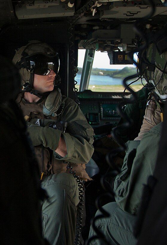 Gunnery Sgt. Paul Coy Jr., a crew chief with Marine Light Attack Helicopter Squadron 367, soaks in the view during a flight around Oahu, Hawaii, as he returns to Marine Corps Air Station Kaneohe Bay, Hawaii, Dec. 5, 2013. The unit celebrated its 70th anniversary in the Marine Corps, Dec. 1., and flew four AH-1W Super Cobra and UH-1Y Huey helicopters over Pearl Harbor to commemorate its history. (U.S. Marine Corps photo by Lance Cpl. Matthew Bragg)