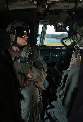 Gunnery Sgt. Paul Coy Jr., a crew chief with Marine Light Attack Helicopter Squadron 367, soaks in the view during a flight around Oahu, Hawaii, as he returns to Marine Corps Air Station Kaneohe Bay, Hawaii, Dec. 5, 2013. The unit celebrated its 70th anniversary in the Marine Corps, Dec. 1., and flew four AH-1W Super Cobra and UH-1Y Huey helicopters over Pearl Harbor to commemorate its history. (U.S. Marine Corps photo by Lance Cpl. Matthew Bragg)