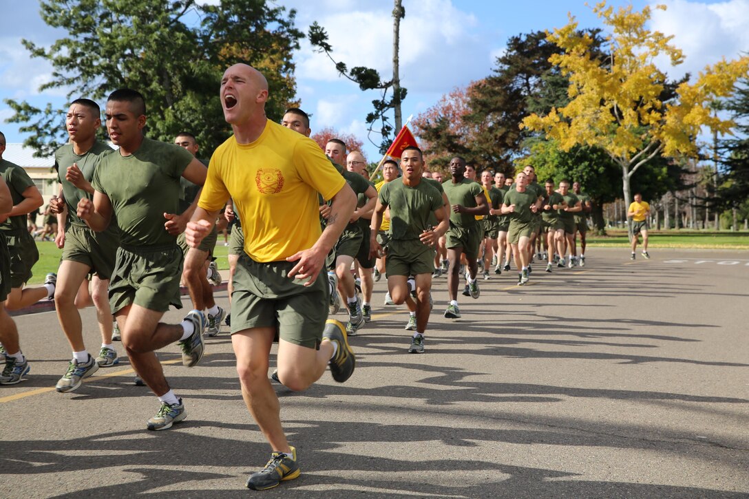 Drill instructors of Company H, 2nd Recruit Training Battalion scream cadences during the motivation run on family day aboard the depot, Dec. 5. Drill instructors gave commands such as “left foot, right foot” which kept the platoon synchronized. 