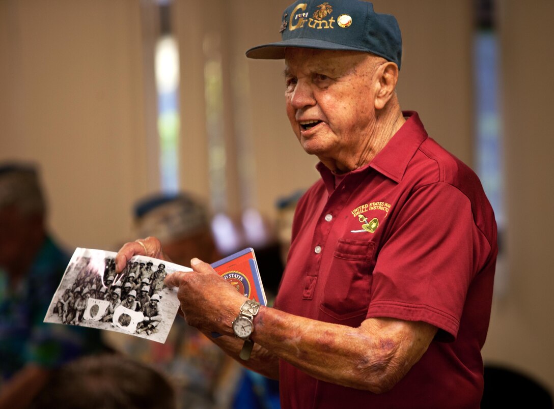 Sgt. Maj. Mike “Iron Mike” Mervosh shows Marines at the Staff Noncommisioned Officer Academy. a photo of him an the Marines he fought with at Iwo Jima during The Greatest Generation Foundation tour at the Staff Noncommissioned Officer Academy Dec. 6, 2013. He enlisted in September 1942, and was awarded personal decorations through World War II and the Korean and Vietnam Wars. He earned 11 personal combat awards with 13 battle stars, 10 unit citations and numerous other campaign and service awards. Now, retired after 35 years of service in the Marine Corps and 19 and a half years as a sergeant major, he continues to tour around to tell people his story.(U.S. Marine Corps photo by Cpl. Nathan Knapke)