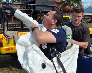 U.S. Air Force Staff Sgt. Eric Stumpff, 612th Air Base Squadron, helps a Honduran first responder don a HAZMAT suit during an American Academy of Pediatric Disaster “Train the Trainer” course at Soto Cano Air Base, Honduras, Dec. 13, 2013. The three-day course provided training to members of the Honduran Academy of Pediatrics, the Honduran Red Cross, Honduran first responders, and members of the Permanent Contingency Commission of Honduras (COPECO) in the planning for and care of pediatric populations post-disaster. (U.S. Air Force photo by Capt. Zach Anderson)