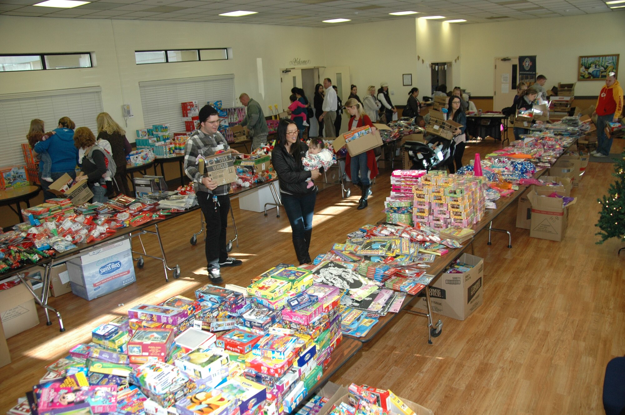 Holiday Toy Drive lands at Travis: Junior enlisted military families navigate through the annex of the First Street Chapel Tuesday afternoon searching for the perfect Christmas gift for their children. The annex was turned into a miniature Toyland courtesy of Operation Homefront, a national non-profit organization, and Dollar Tree stores for the 2013 Holiday Toy Drive program, distributing toys and gift cards to registered participants. This year marks the seventh annual joint campaign by Operation Homefront and Dollar Tree in a show of the Nation’s appreciation and to help support military families during the holiday season. (U.S. Air Force photo / Jim Spellman)