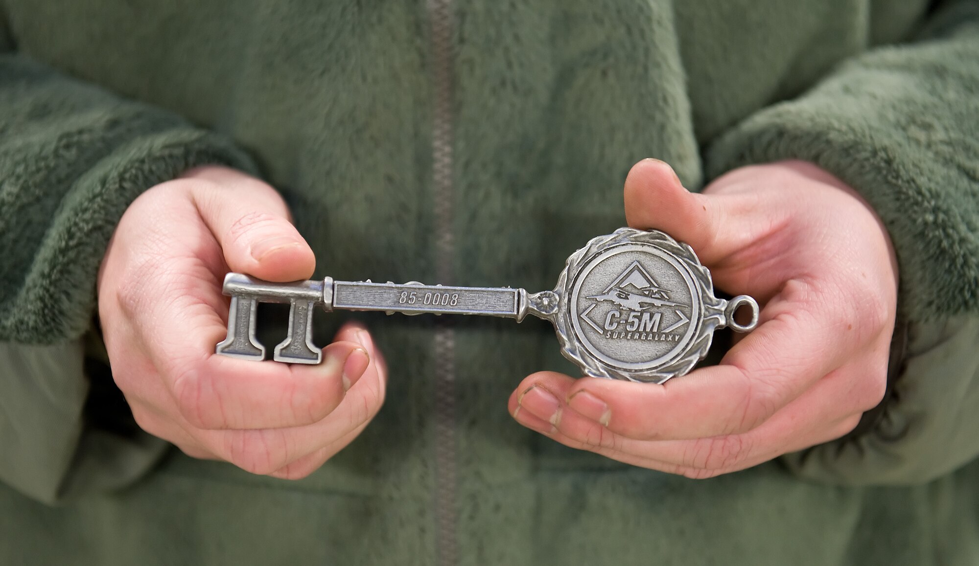 Staff Sgt. Heath Hackwell, 436th Aircraft Maintenance Squadron dedicated crew chief, holds the ceremonial aircraft key to C-5M 85-0008 Dec. 13, 2013, at Dover Air Force Base, Del. Team Dover received its 14th C-5M Super Galaxy out of 18. (U.S. Air Force photo/Roland Balik)