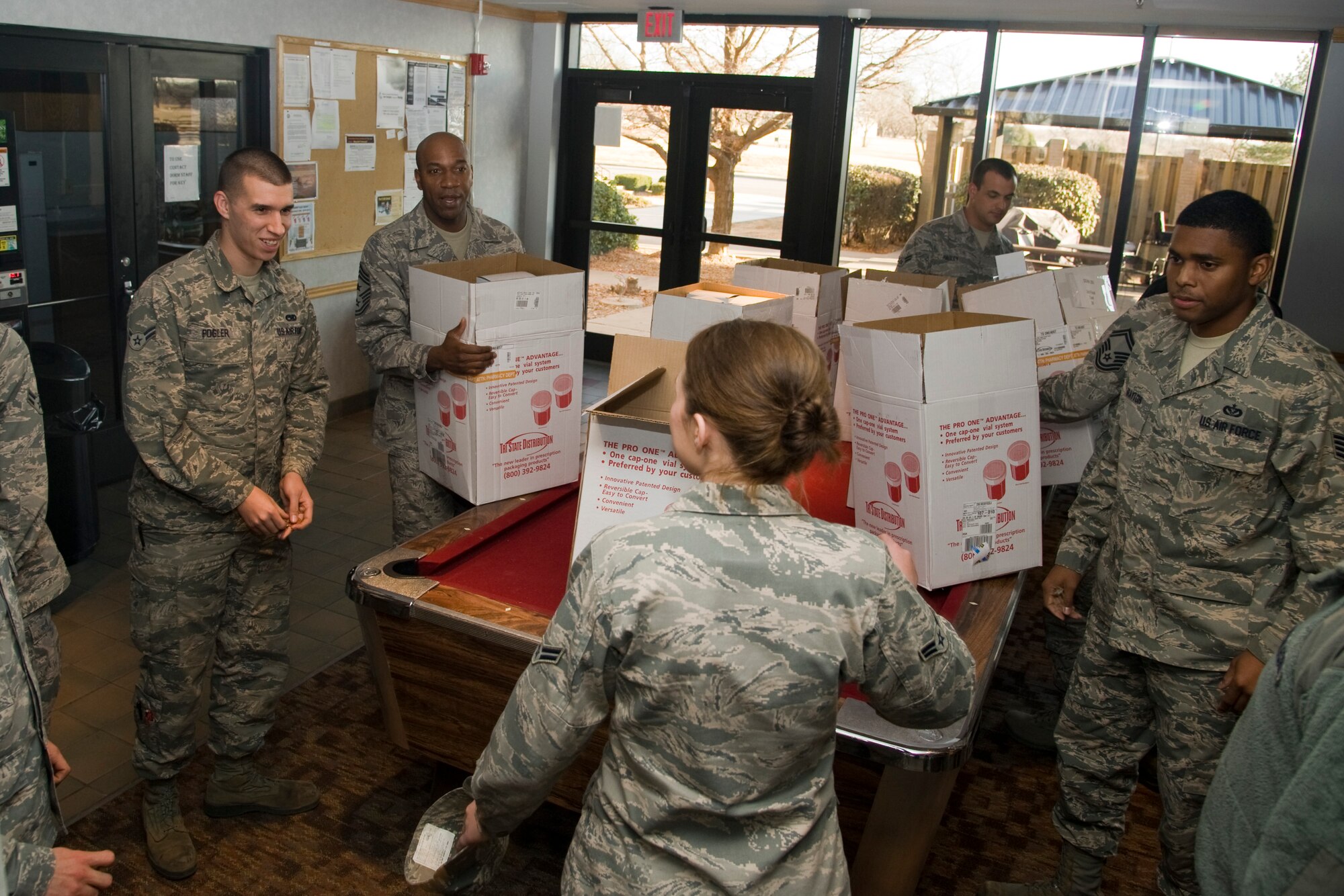 First sergeants, chief master sergeants and Airmen from the Dorm Council prepare to deliver boxes of cookies to dorm residents Dec. 11, 2013, at McConnell Air Force Base, Kan. The delivery is part of the annual McConnell AFB cookie drop, an incentive carried out by base leadership to improve morale and welfare to junior members of Team McConnell during the holidays. (U.S. Air Force photo/Airman 1st Class John Linzmeier)