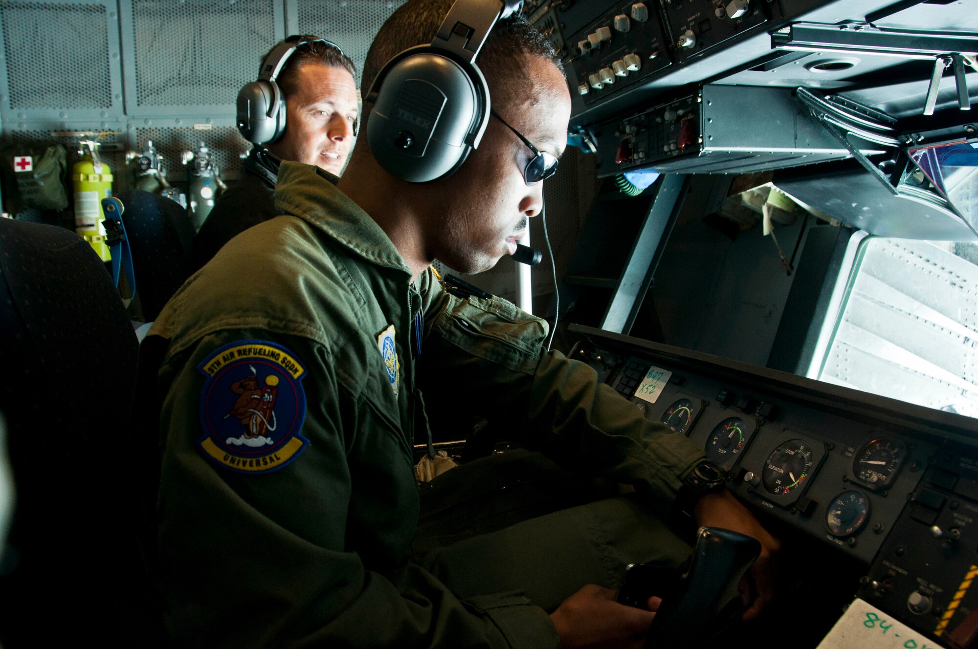 Airman 1st Class Derrell Vann, 9th Air Refueling Squadron boom operator, refuels a C-17 Globe Master III with Chris Polen, 9th ARS honorary commander Dec. 6 during a flight that was part of the honorary commander 60th Operations Group tour. (U.S. Air Force photo/Senior Airman Madelyn Brown)