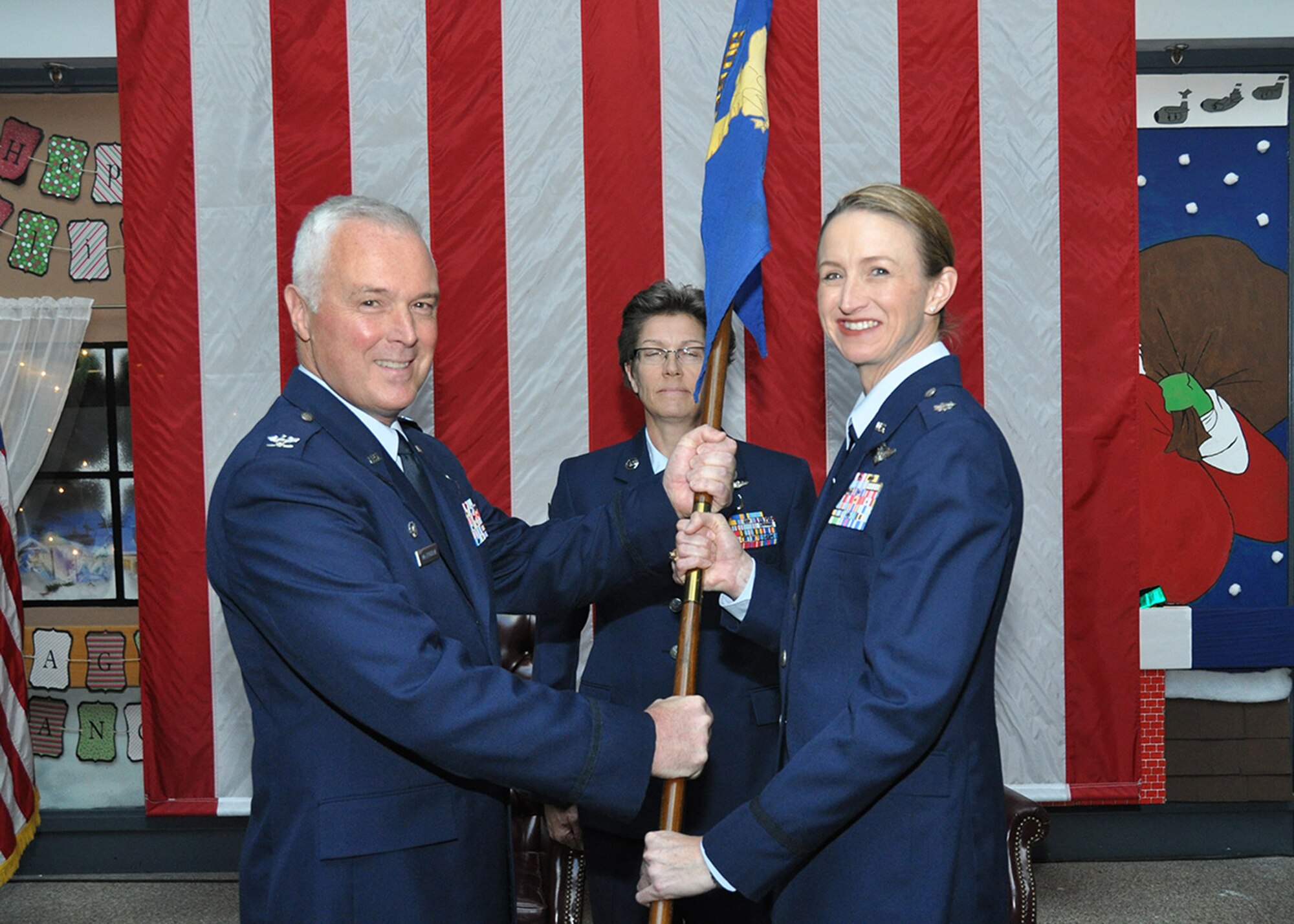 TRAVIS AIR FORCE BASE, Calif. -- Col. Scott McLaughlin, 349th Operations Group commander, passes the 349th Aeromedical Evacuation Squadron guidon to Lt. Col. Anita Fligge, during an assumption of command held here during the Dec. A flight. Lt. Col. Fligge joined the 349 AES in 1998 and progressed to her current position as the commander. (U.S. Air Force photo/Senior Master Sgt. Robert Wade/Released)