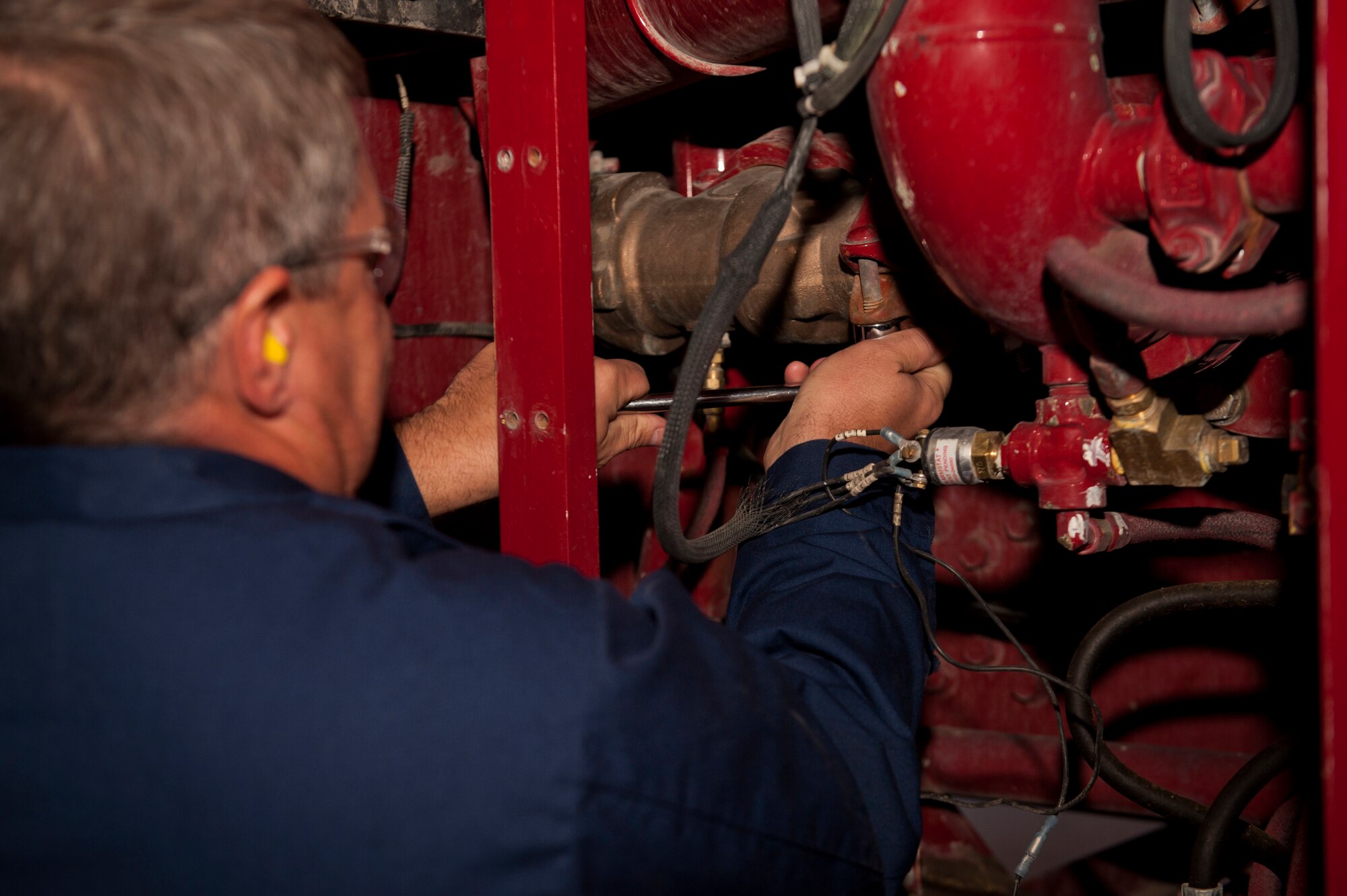 Colonel Kevin Bennett, 49th Mission Support Group commander removes the relief valve from a P-19 fire truck at Holloman Air Force Base, N.M., Dec. 11. Bennett spent the day working hands-on with fire truck mechanics of the 49th Logistics Readiness Squadron to get an insight of their daily life and connect with the airmen. (U.S. Air Force photo by Airman 1st Class Aaron Montoya/Released)