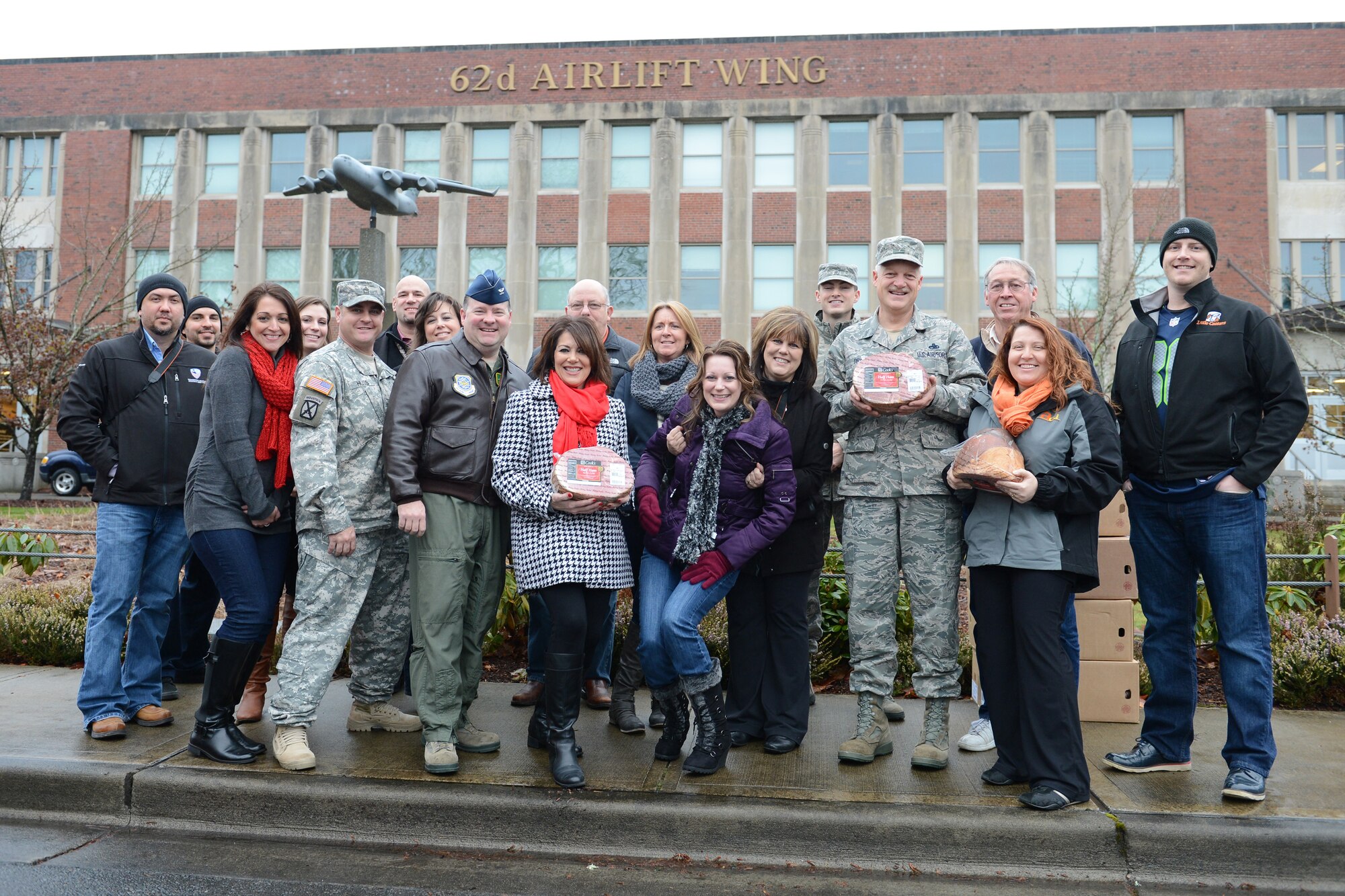 Members of the 62nd Airlift Wing command pose for a photo with local civic leaders during Operation Ham Grenade, Dec. 13 at Joint Base Lewis-McChord, Wash. During Operation Ham Grenade, more than 390 hams were donated to JBLM families by local community partners. (U.S. Air Force photo/Airman 1st Class Jacob Jimenez)   