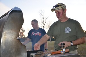 Master Chief Petty Officer Robert Bostic, Naval Consolidated Brig Charleston command master chief (right), grills steaks at a fundraising event held by the LowCountry Chief Petty Officer Association at Joint Base Charleston – Weapons Station, Goose Creek, S.C. The event held Dec. 6, 2013, raised nearly $1,500 for local Army veteran Walker Grainger who has recently fallen on hard times and was featured in a local news story. (U.S. Navy Photo by Petty Officer 3rd Class Jason Pastrick)

