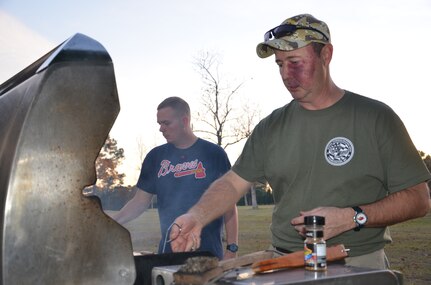 Master Chief Petty Officer Robert Bostic, Naval Consolidated Brig Charleston command master chief (right), grills steaks at a fundraising event held by the LowCountry Chief Petty Officer Association at Joint Base Charleston – Weapons Station, Goose Creek, S.C. The event held Dec. 6, 2013, raised nearly $1,500 for local Army veteran Walker Grainger who has recently fallen on hard times and was featured in a local news story. (U.S. Navy Photo by Petty Officer 3rd Class Jason Pastrick)

