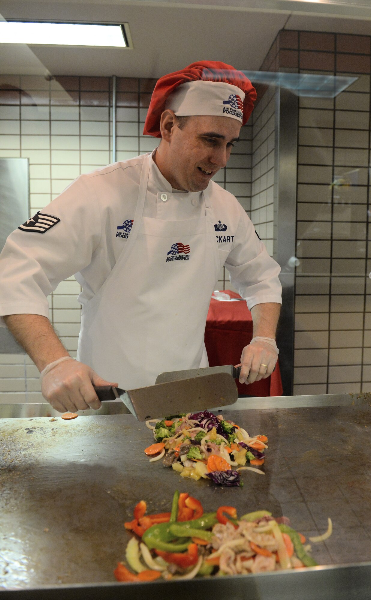 Staff Sgt. Michael Lockart, 354th Force Support Squadron food services shift supervisor, prepares Mongolian Barbecue Dec. 11, 2013, Eielson Air Force Base, Alaska. Icemen were able to choose from many different meats, vegetables and sauces to create the taste they wanted. (U.S. Air Force photo by Senior Airman Ashley Nicole Taylor/Released)