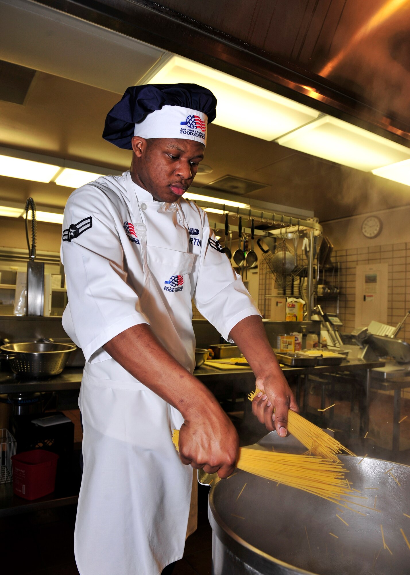 Airman 1st Class Braxton Martin, 354th Force Support Squadron food services apprentice, boils noodles for Asian bourbon beef Dec. 11, 2013, Eielson Air Force Base, Alaska. Different Mongolian flavored dishes were prepared for the Mongolian Barbecue meal hosted by the Two Seasons Dining Facility. (U.S. Air Force photo by Senior Airman Ashley Nicole Taylor/Released)