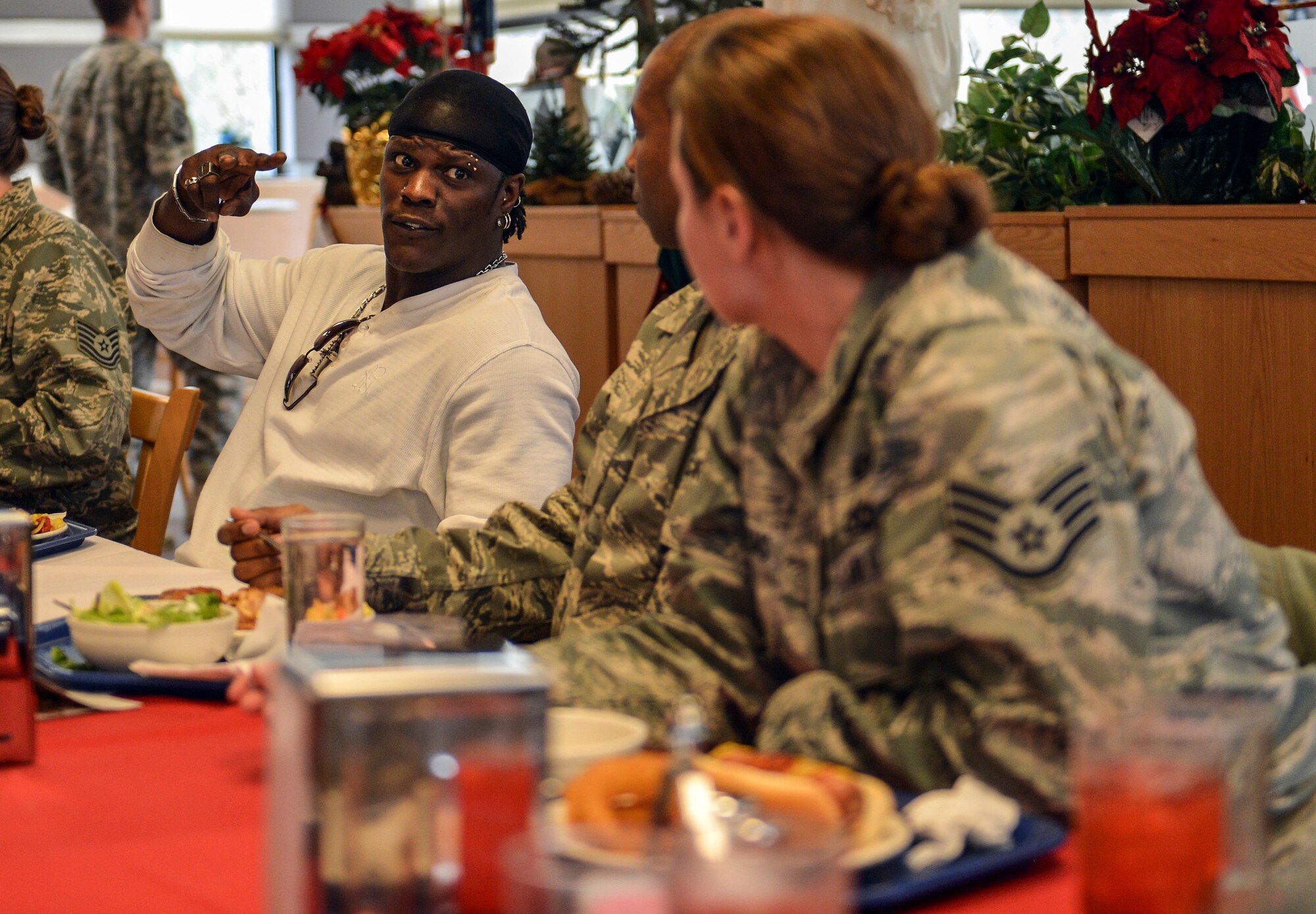 World Wresting Entertainment superstar, R-Truth, chats with Airmen during lunch at the McChord Field dining facility, Dec. 11, 2013, at Joint Base Lewis-McChord, Wash. WWE superstars and divas toured JBLM meeting and greeting service members prior to putting on a show at a McChord Field hangar later in the evening. (U.S. Air Force photo/Staff Sgt. Jason Truskowski)