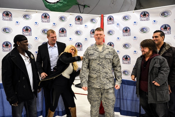 World Wrestling Entertainment Diva, Rosa Mendes, tacks on a stripe to the recently promoted Tech. Sgt. John Hruska, 627th Logistics Readiness Squadron central storage NCO in charge, Dec. 11, 2013 at Joint Base Lewis-McChord, Wash. Mendes, along with other WWE entertainers, toured McChord Field signing autographs as part of their Tribute to the Troops visit to JBLM. (U.S. Air Force photo/Staff Sgt. Jason Truskowski)