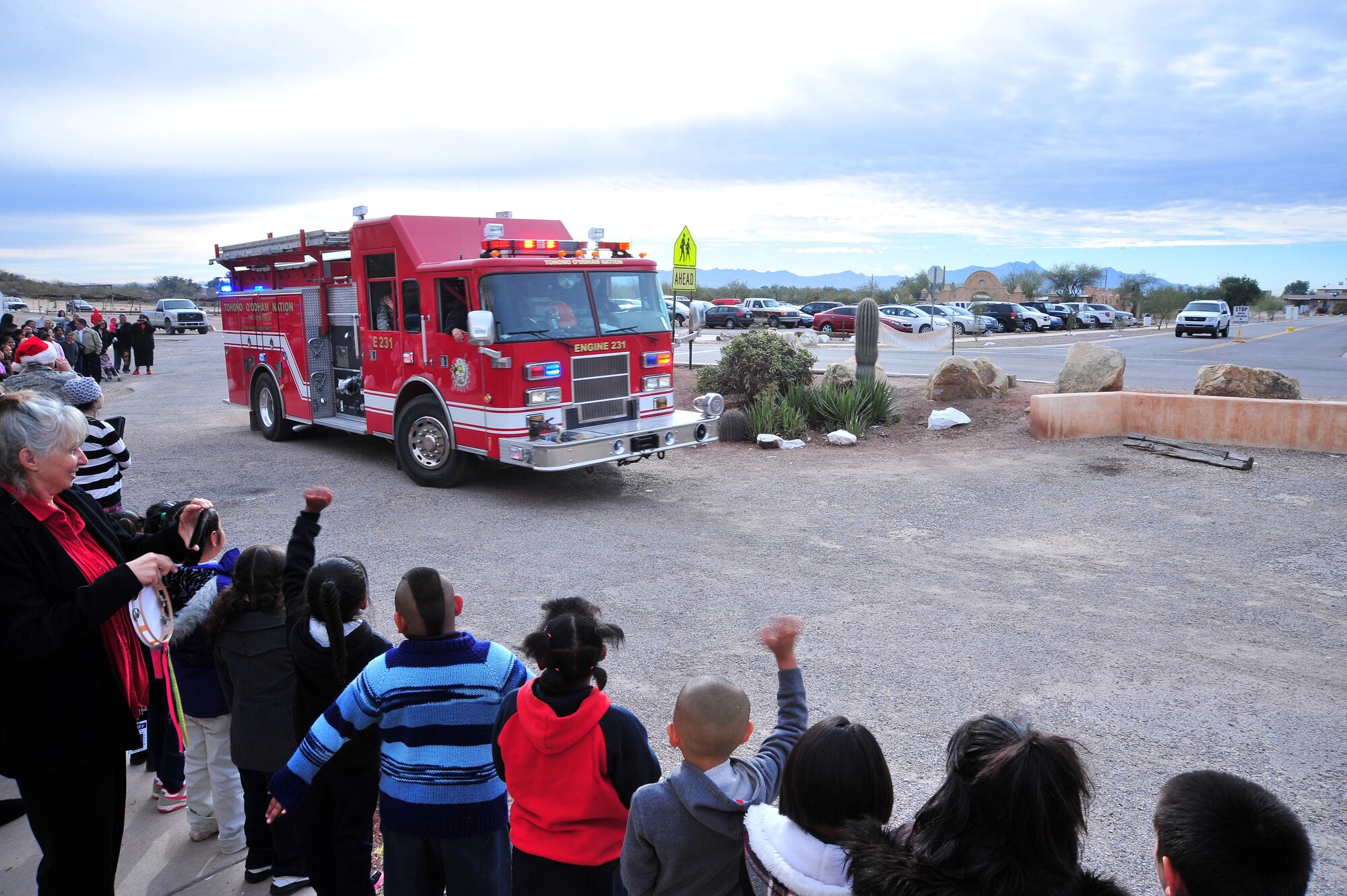 Students line up to greet Santa as he arrives in a fire truck at the San Xavier Mission School in Tucson, Ariz., Dec.  10, 2013. The Santas-in-Blue program is a way for Davis-Monthan Air Force Base to strengthen its relationship with the local community. San Xavier Mission School is one of three Schools that will be visited by the Santas-in-Blue program this year.(U.S. Air Force photo by Senior Airman Josh slavin/Released)