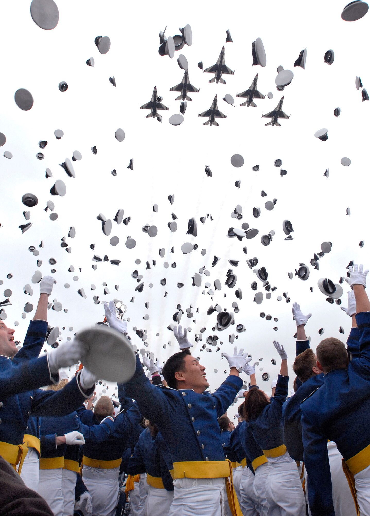 Newly-minted Air Force lieutenants celebrate their graduation at Falcon Stadium as the Air Force Thunderbirds fly overhead. The Thunderbirds just announced their 2014 flying schedule which includes a flyover for the Academy's 2014 graduating class.