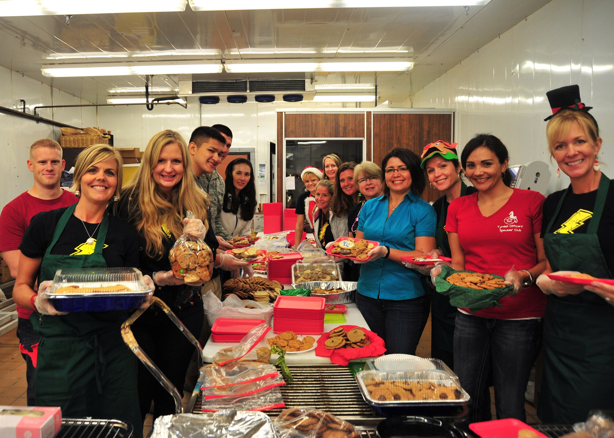 Tyndall’s Cookie Caper elves pose for a group photo after packaging more than 800 dozen cookies, donated by Team Tyndall families and local businesses Dec. 9 at the base commissary. The Annual Cookie Caper program is designed to deliver cookies to Airmen living in the dormitories. (U.S. Air Force photo by Airman 1st Class Sergio Gamboa)

