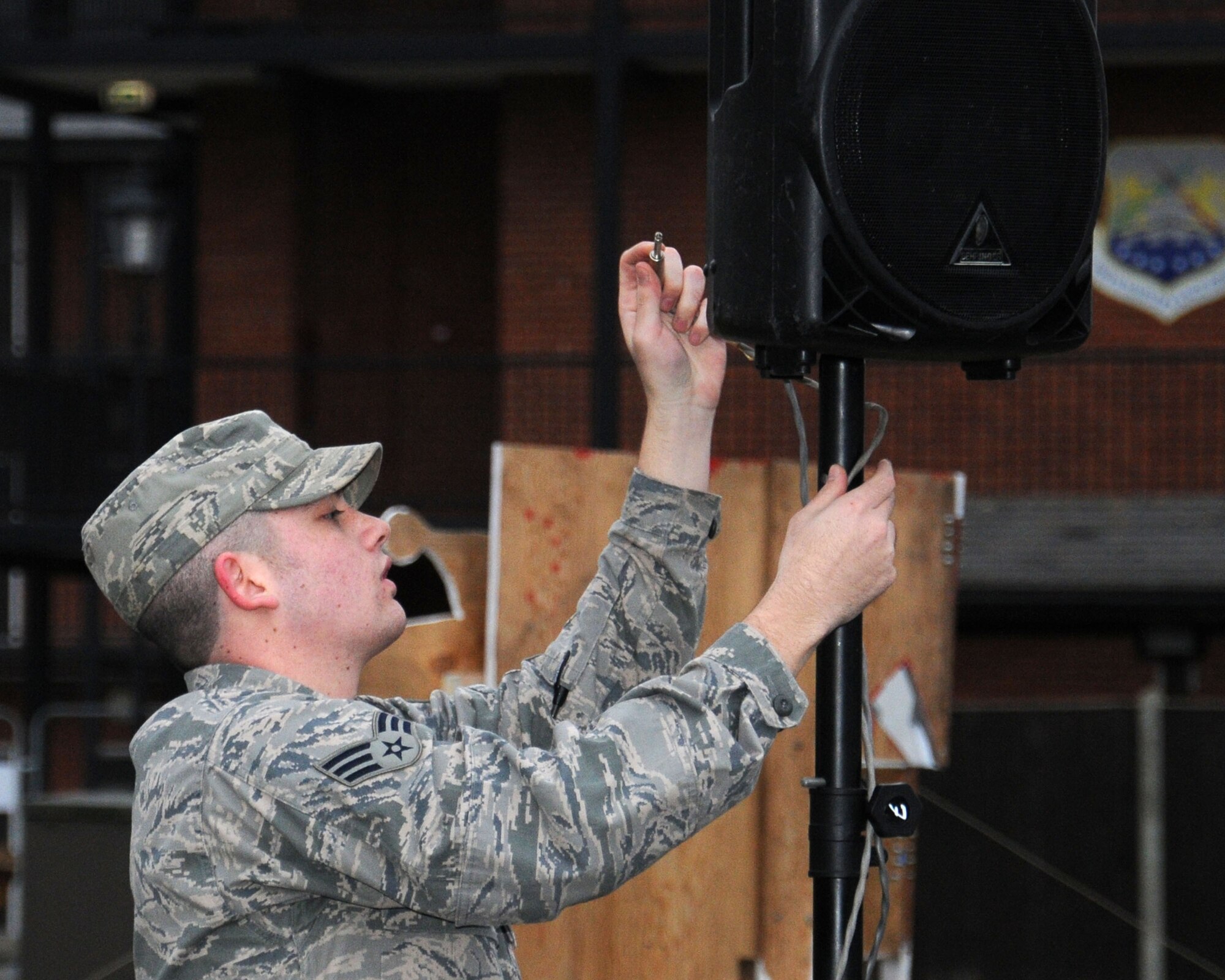 U.S. Air Force Senior Airman Calvin Robertson, 100th Communication Squadron Radio Frequency Transmission technician from San Antonio, connects a speaker for the 100th Air Refueling Wing Tree Lighting Ceremony Dec. 6, 2013, on RAF Mildenhall, England. The radio frequency transmissions shop personnel helped set up the public address system for the Christmas tree lighting ceremony. The work center also provides support for the base wide alert system known as the "Giant Voice." (U.S. Air Force photo by Gina Randall/Released)