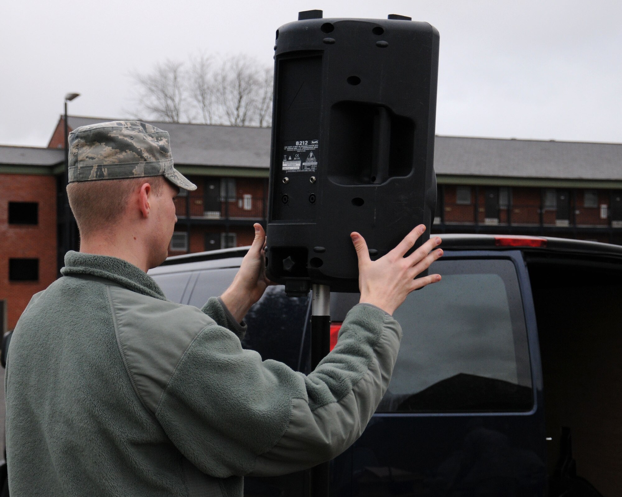 U.S. Air Force Senior Airman Jordan Thomas, 100th Communication Squadron Radio Frequency Transmissions technician from Oakgrove, Minn., sets up a speaker on a tripod for the 100th Air Refueling Wing Tree Lighting Ceremony Dec. 6, 2013, on RAF Mildenhall, England. The radio frequency transmissions shop personnel helped set up the public address system that was used for the Christmas tree lighting ceremony. The work center also provides land mobile radio support which includes 1,300 assets base wide. (U.S. Air Force photo by Gina Randall/Released) 