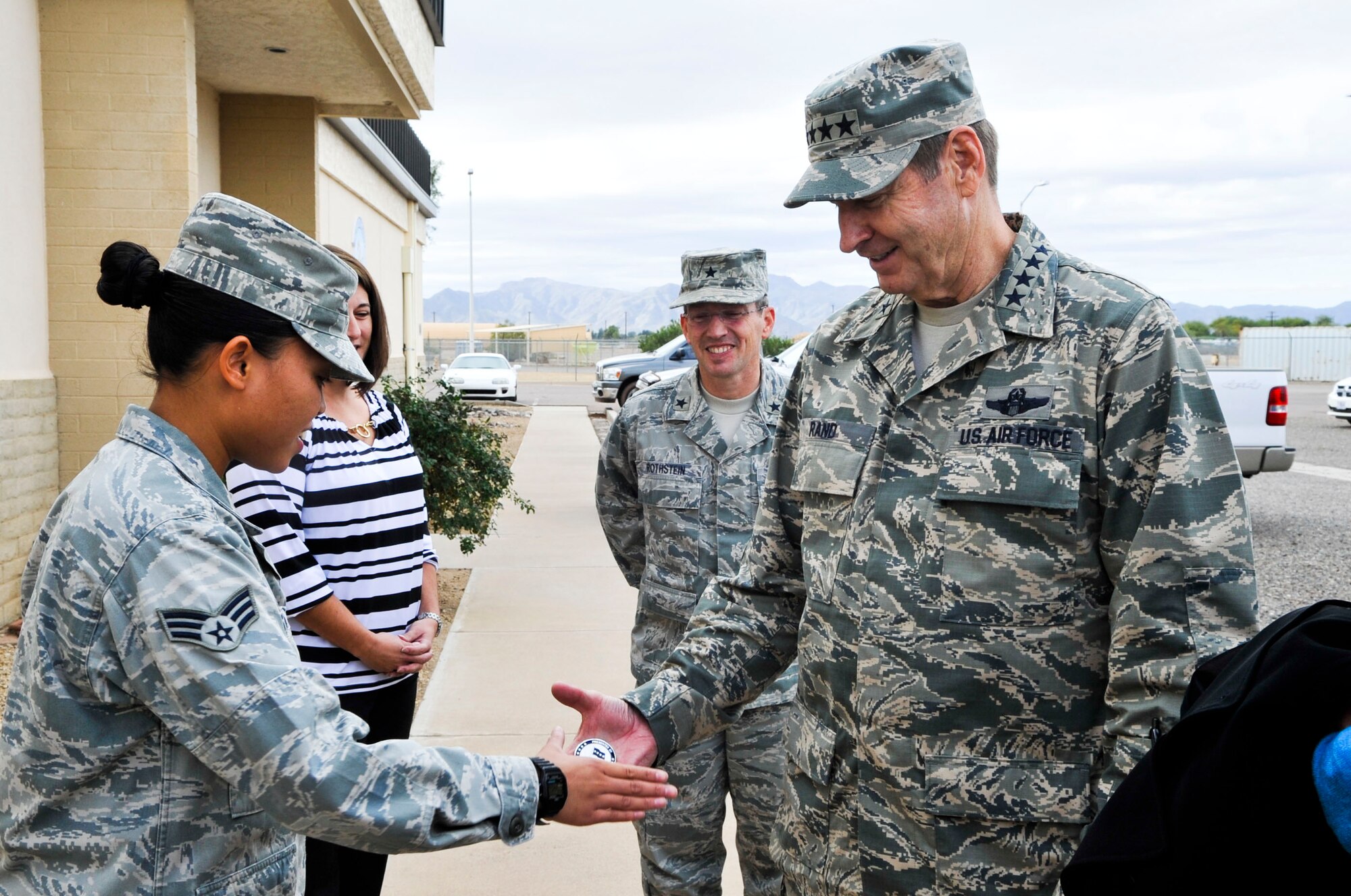 Gen. Robin Rand, Air Education and Training Command commander, presents a coin to Senior Airman Leonila Celestino, 607th Air Control Squadron knowledge operations management journeyman, Dec. 4 outside the 607th ACS building. Rand, a former wing commander at Luke, visited the base to talk to Airmen about his priorities and vision for AETC. (U.S. Air Force photo/Senior Airman David Owsianka)