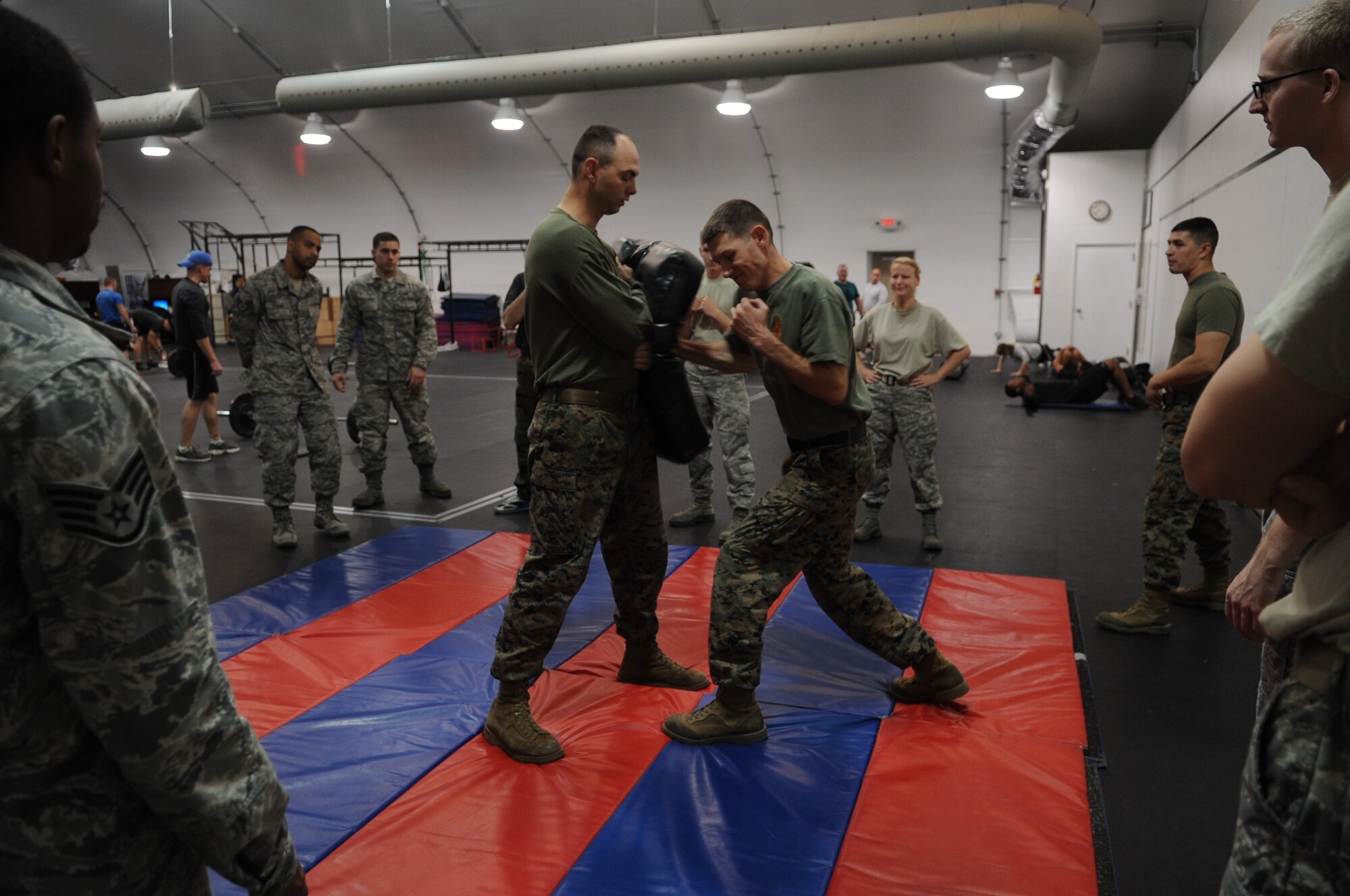 Marine Staff Sgt. Glen Cline, center, 6th Engineer Support Battalion maintenance chief and combative course instructor, demonstrates a punch Monday during the Hand 2 Hand combative course held inside the Luke Air Force Base Warrior Fitness Center. The Hand 2 Hand combative course is a 10-day class teaching students the basics of the Marine Corps Martial Arts Program. Introduced in 2001, the MCMAP combines close quarters combat techniques with morale and team-building instruction. (U.S. Air Force photo/Staff Sgt. Nestor Cruz)