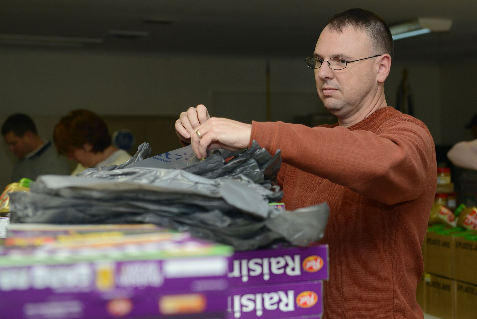 U.S. Air Force Maj. Albert Denney, Air Land Sea Application Center action officer, packs food baskets for the Peninsula Agency on Aging program in Newport News, Va., Dec. 10, 2013. Members built more than 370 food baskets for the home-bound elderly. (U.S. Air Force photo by Airman 1st Class Kimberly Nagle/Released)