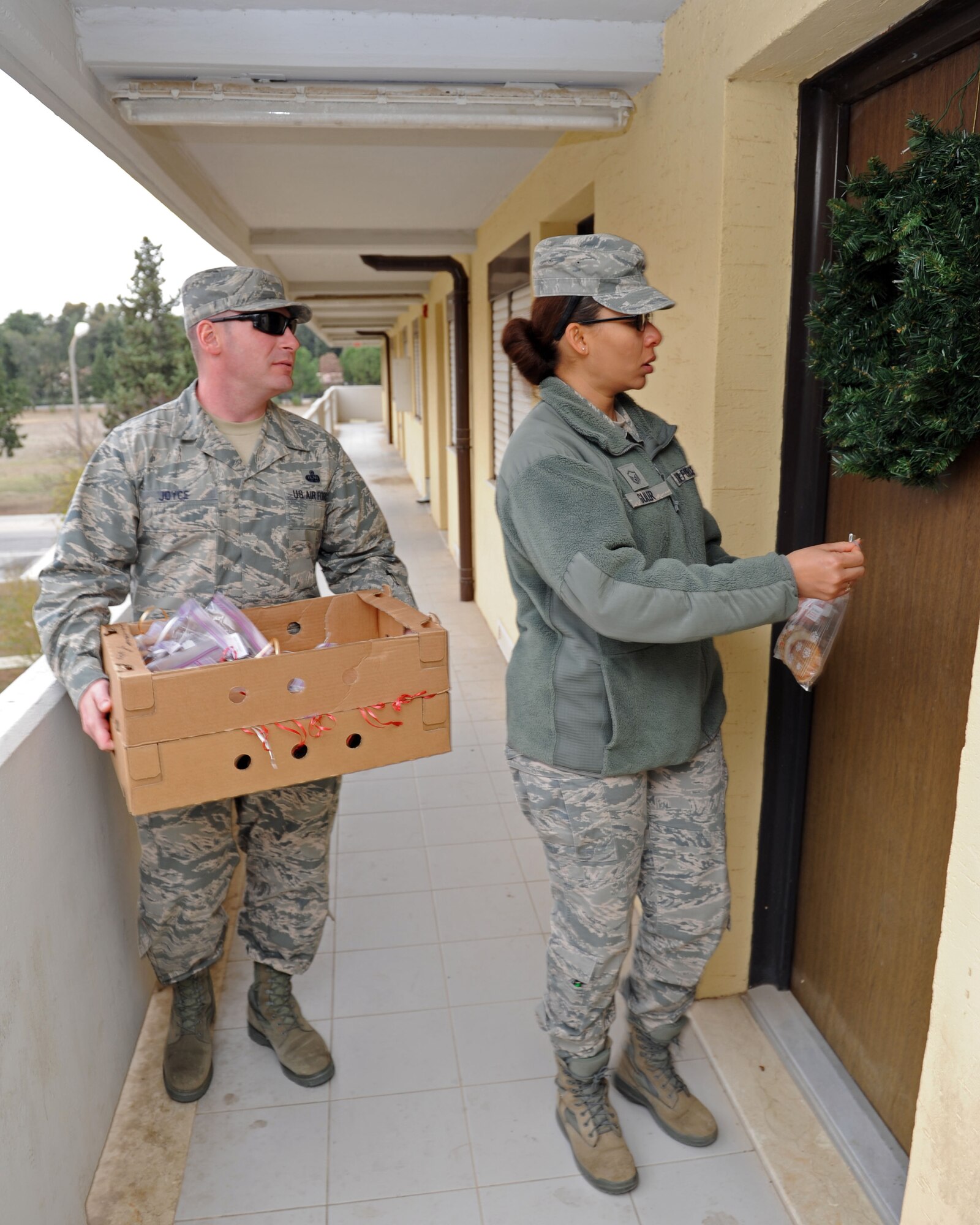 First sergeants Master Sgt. William Joyce, 39th Logistics Readiness Squadron, and Master Sgt. Kimberly Guler, 39th Air Base Wing wing staff agencies and 39th Comptroller Squadron, deliver cookies Dec. 10, 2013, at Incirlik Air Base, Turkey. The Great Cookie Caper has been a tradition on Incirlik AB for more than 20 years. (U.S. Air Force photo by Senior Airman Chase Hedrick/Released)