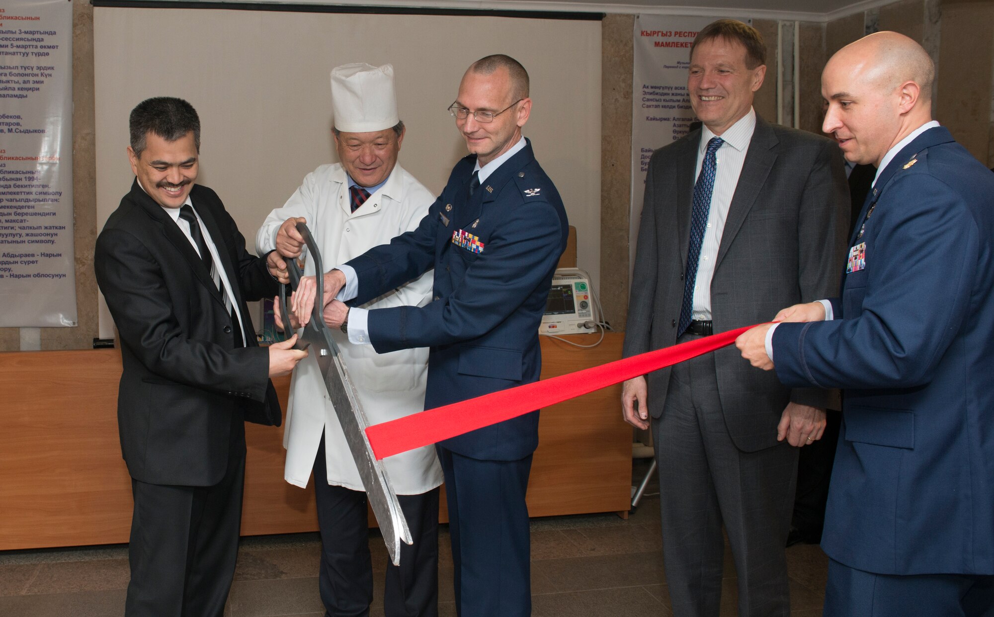 Distinguished visitors, local civic leaders and leadership from the Transit Center at Manas, cut a ribbon to officially signify a $132,000 medical equipment donation during a ceremony at a women’s prenatal clinic in Bishkek, Kyrgyzstan, Dec. 11, 2013. The 56 pieces of medical equipment will be distributed to four different hospitals in the Naryan province, the largest region in Kyrgyzstan with one of the smallest populations, about 264,000. (U.S. Air Force photo/Staff Sgt. Travis Edwards)