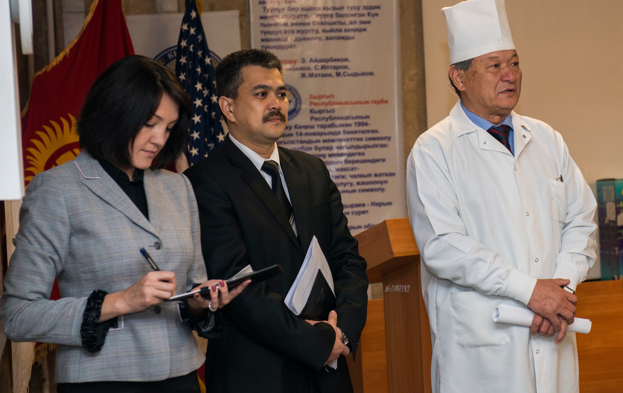 Azamat Alimbaevich Alimbaev, right, the head doctor for a women’s prenatal clinic in Bishkek, Kyrgyzstan, gives remarks while the Kyrgyz Republic Deputy Minister of Health, Kaliev Marat, middle, listens and Staff Sgt. Nadia Wolfe, 376th Air Expeditionary Wing Theater Security Cooperation member takes notes to translate into English during medical equipment dedication ceremony Dec. 11, 2013. The donated equipment consisted of 46 electrocardiograms (EKG) machines, five defibrillators and five bedside monitors to aid in the prevention and detection of cardiovascular disease, the leading cause of death in Kyrgyzstan (nearly 50 percent). Wolfe is deployed from Camp Bullis, Texas, and native of San Antonio, Texas. (U.S. Air Force photo/Staff Sgt. Travis Edwards)