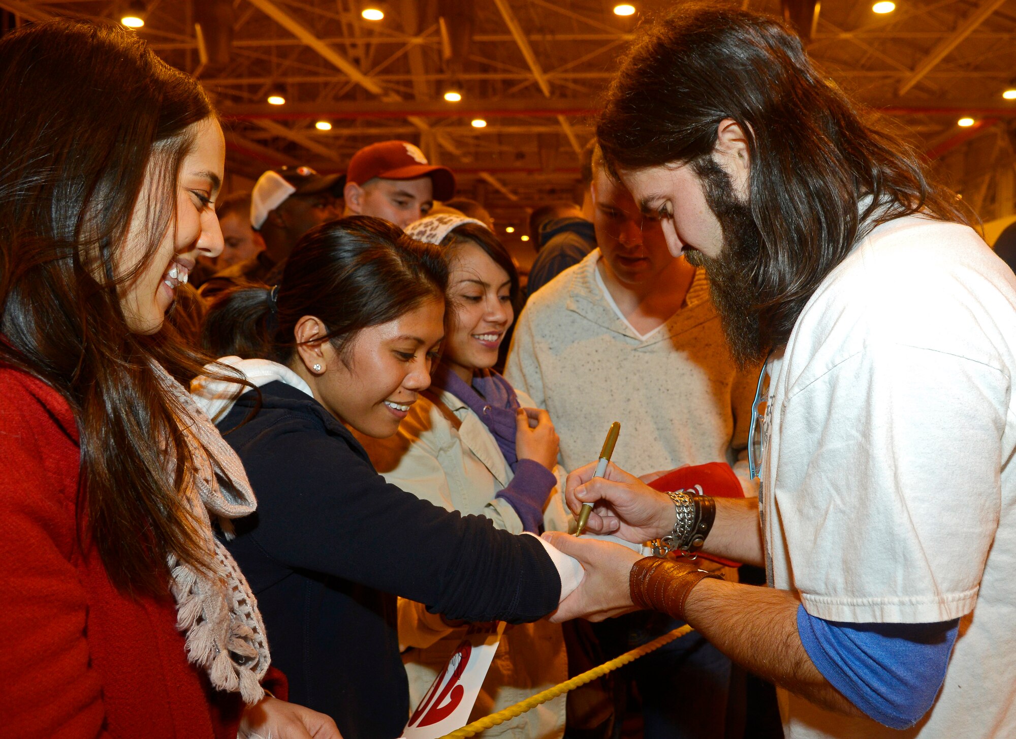 Jep Robertson, “Duck Dynasty” reality TV personality, signs autographs and takes photos with audience members during the United Services Organization’s Annual Chairman’s Holiday Tour, Dec. 11, 2013, at Aviano Air Base, Italy.  The USO brought several celebrities from the sports, TV and music industry to entertain and show appreciation to the troops.  (U.S. Air Force photo/ Airman 1st Class Deana Heitzman)