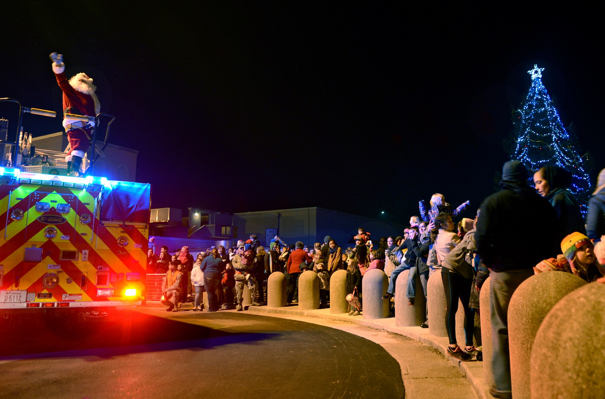 Members of Team Aviano wave to Santa Clause during the Aviano Holiday Tree Lighting event Dec. 12, 2012, at Aviano Air Base, Italy. Along with a visit from Santa, guests sang along with members of the Aviano Community Theater who performed a variety of holiday carols. Airmen and families also enjoyed cookies and hot chocolate as they counted down to the tree lighting. (U.S. Air Force photo/Senior Airman Jessica Hines) 