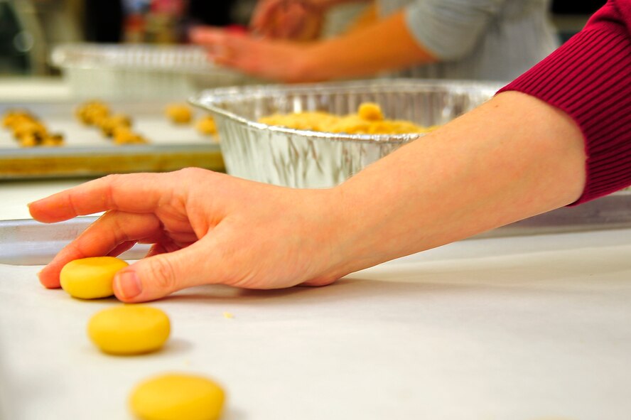 Lisa Hook places sugar cookie dough onto a baking sheet during the Cookie Caper at Misawa Air Base, Japan, Dec. 9, 2013. Each year Cookie Caper volunteers from the Misawa community bake sweets during the holiday season for single and unaccompanied service members on the base. (U.S. Air Force photo by Staff Sgt. Nathan Lipscomb) 