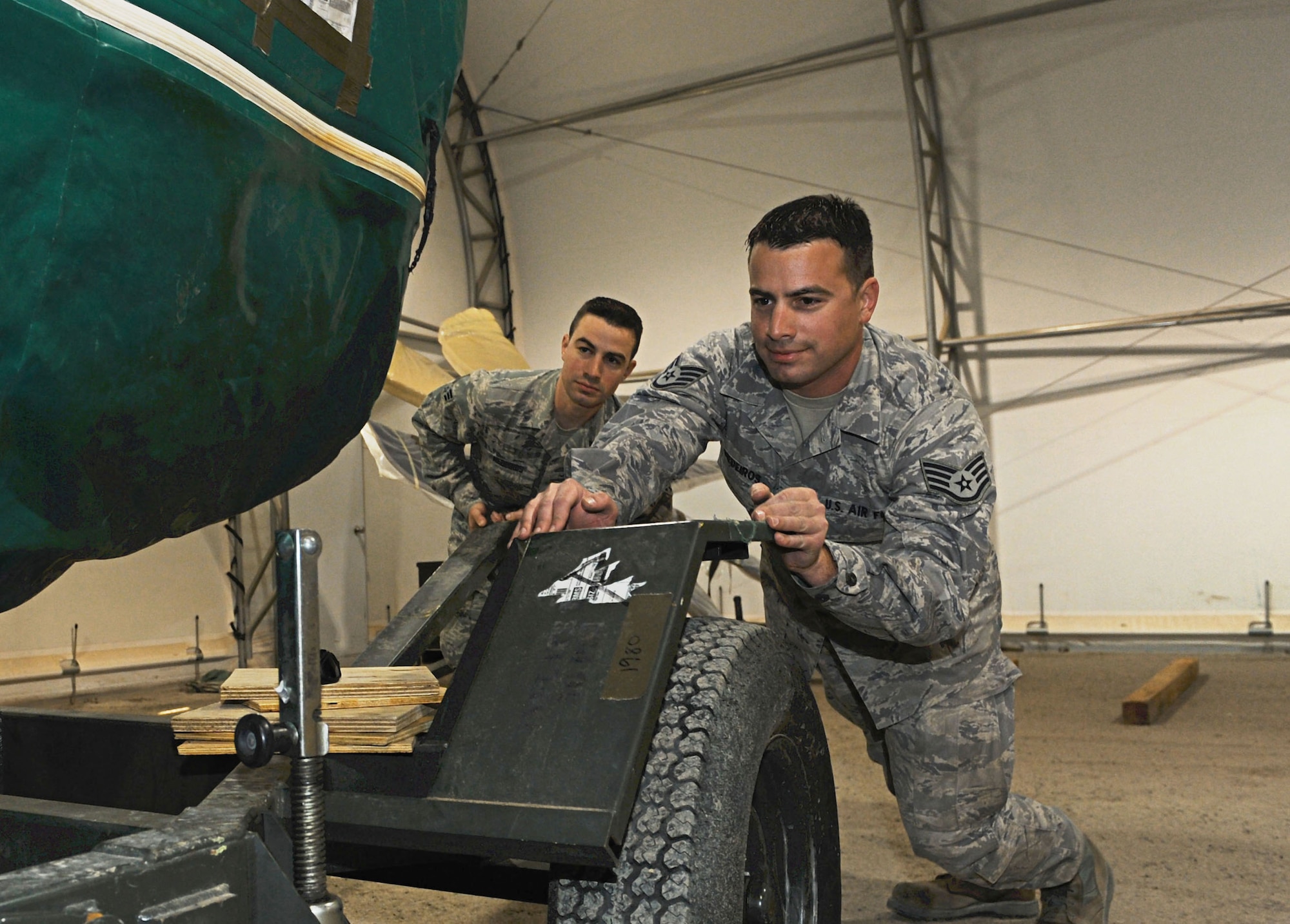 Senior Airman Barrington and Staff Sgt. William Medeiros both from the 386th Expeditionary Aircraft Maintenance Squadron, prepares a spare engine for a C-130 J, undisclosed location Southwest Asia. The Medeiros brothers deployed out of the 143rd Airlift Wing Rhode Island Air National Guard, Quonset Point Air National Guard Station and are natives of Rhode Island. (U.S. Air Force photo by Senior Airman Desiree W. Moye)